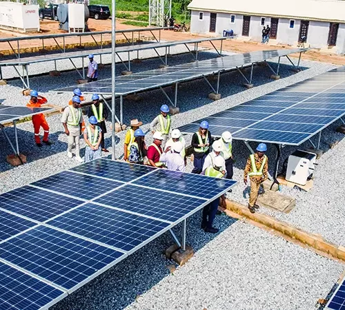 Toto Community solar installation site with engineers and staff inspecting ground-mounted solar panels
